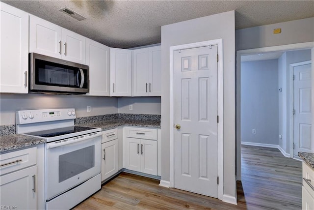 3957 Driftwood Way, Williamsburg, VA 23188 - kitchen featuring stainless steel microwave, white range with electric cooktop, white cabinetry, light wood-type flooring, and a textured ceiling