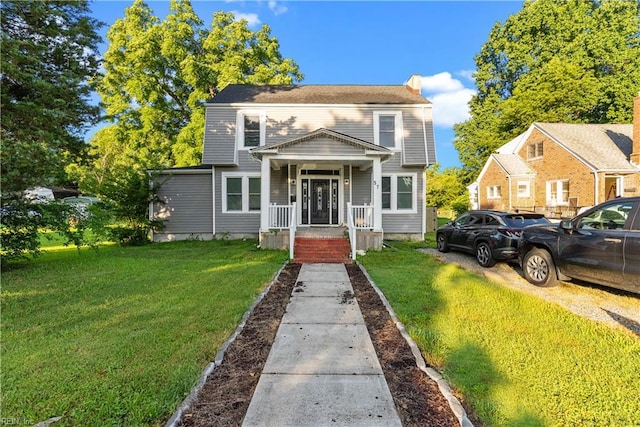57 Locust Ave, Hampton, VA 23661 - view of front of house featuring a front yard, a chimney, and a porch