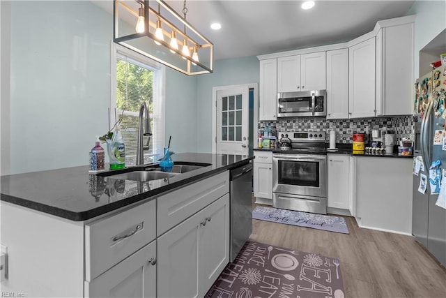57 Locust Ave, Hampton, VA 23661 - kitchen featuring appliances with stainless steel finishes, white cabinetry, light wood-style floors, decorative backsplash, and recessed lighting