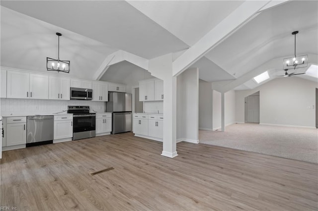 1320 Clay St, Franklin, VA 23851 - kitchen featuring stainless steel appliances, a chandelier, open floor plan, white cabinets, and high vaulted ceiling