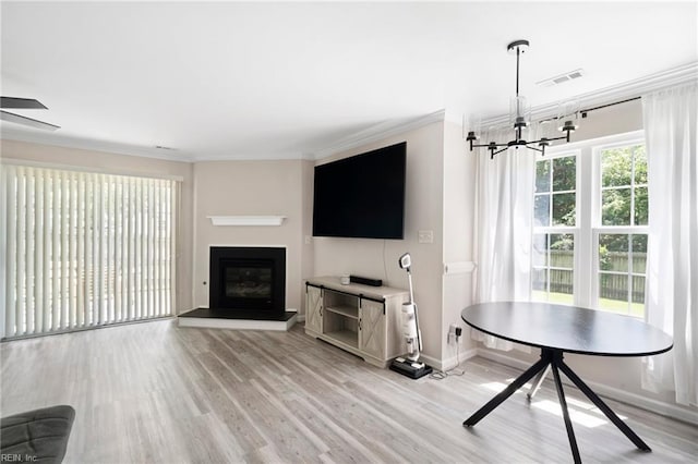 200 Burgundy Rd, Williamsburg, VA 23185 - living room featuring ornamental molding, light wood-type flooring, a chandelier, a fireplace with raised hearth, and a ceiling fan