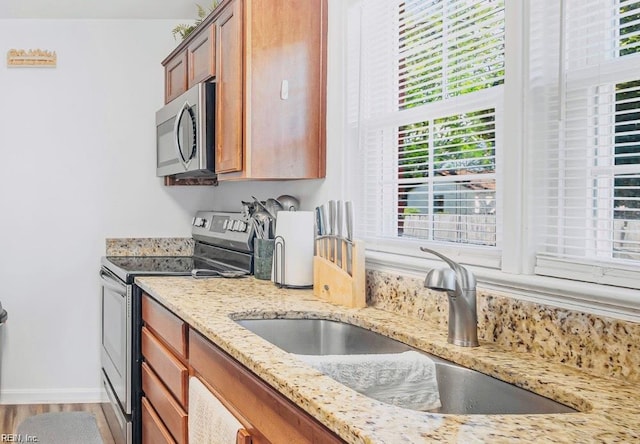 24 Saint Albans Dr, Hampton, VA 23669 - kitchen featuring appliances with stainless steel finishes, brown cabinets, light stone counters, and light wood finished floors
