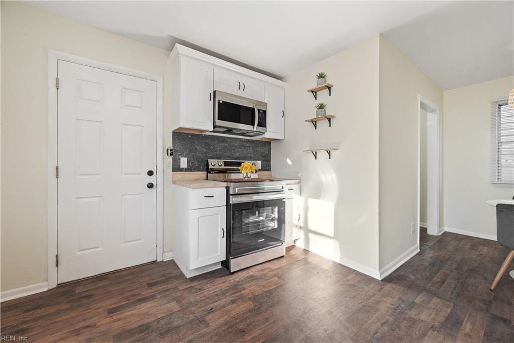 1027 30th St, Newport News, VA 23607 - kitchen featuring stainless steel appliances, tasteful backsplash, white cabinets, dark wood-type flooring, and light countertops