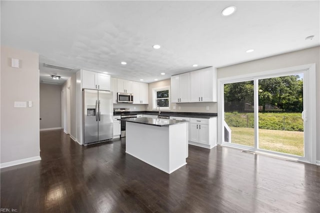 703 Terrace Dr, Newport News, VA 23601 - kitchen with appliances with stainless steel finishes, white cabinets, dark countertops, recessed lighting, and a center island