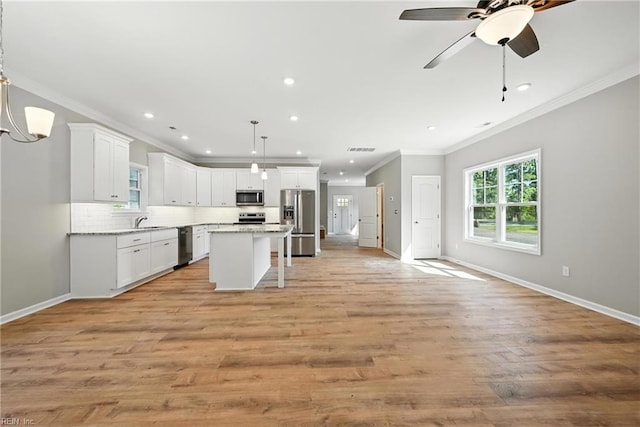 2152 Millville Rd, Chesapeake, VA 23323 - kitchen featuring appliances with stainless steel finishes, ornamental molding, open floor plan, backsplash, and white cabinets