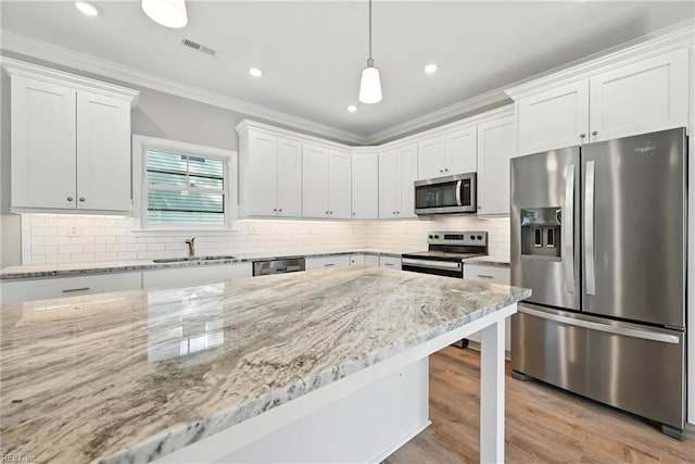 2152 Millville Rd, Chesapeake, VA 23323 - kitchen with appliances with stainless steel finishes, white cabinetry, light stone counters, crown molding, and hanging light fixtures