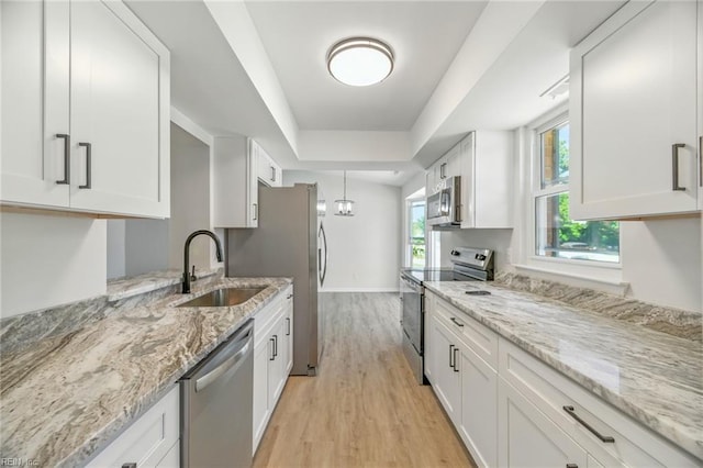 1409 Amberley Forest Rd, Virginia Beach, VA 23453 - kitchen featuring stainless steel appliances, light wood finished floors, white cabinetry, light stone counters, and a raised ceiling