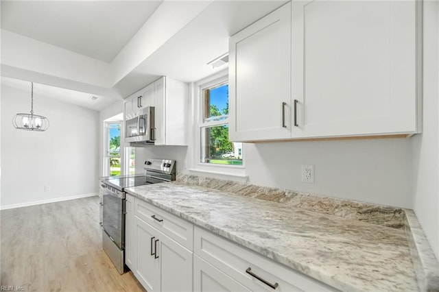 1409 Amberley Forest Rd, Virginia Beach, VA 23453 - kitchen with stainless steel appliances, light wood finished floors, white cabinetry, a chandelier, and light stone counters