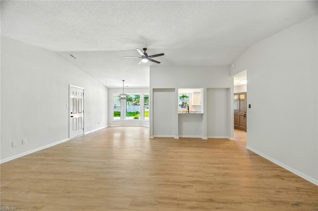 1409 Amberley Forest Rd, Virginia Beach, VA 23453 - unfurnished living room with ceiling fan, vaulted ceiling, light wood-style flooring, a textured ceiling, and a chandelier