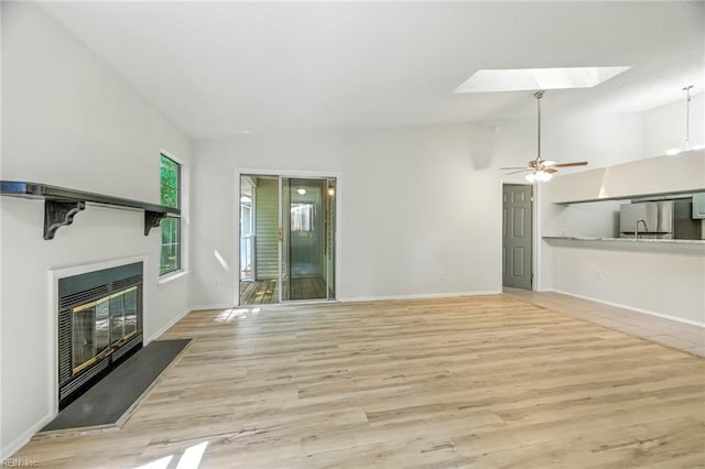647 Crows Nest Ct, Virginia Beach, VA 23462 - unfurnished living room with a skylight, a glass covered fireplace, wood finished floors, vaulted ceiling, and ceiling fan