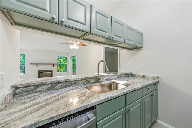 647 Crows Nest Ct, Virginia Beach, VA 23462 - kitchen featuring green cabinetry, light stone counters, a ceiling fan, a glass covered fireplace, and stainless steel dishwasher
