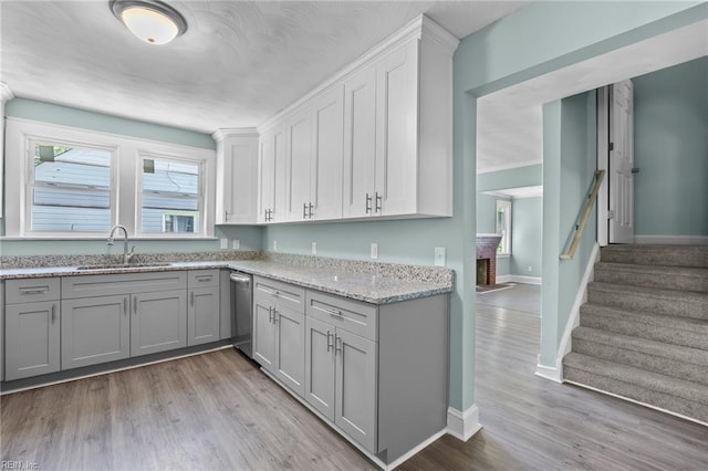 1003 Douglas Ave, Portsmouth, VA 23707 - kitchen with gray cabinets, light wood-style floors, light stone counters, and dishwasher