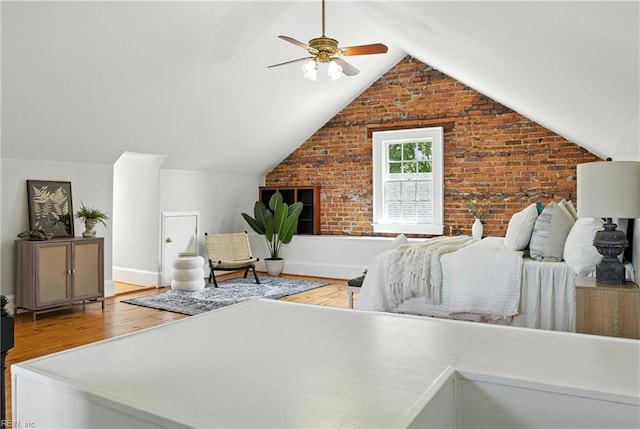 227 N Saratoga St, Suffolk, VA 23434 - bedroom with light wood finished floors, vaulted ceiling, brick wall, and a ceiling fan