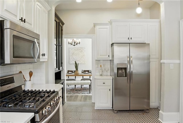 227 N Saratoga St, Suffolk, VA 23434 - kitchen with stainless steel appliances, light countertops, arched walkways, and white cabinetry