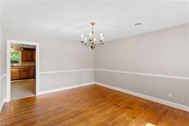 416 N Broad St, Suffolk, VA 23434 - spare room featuring a chandelier and light wood-type flooring