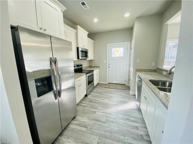 1400 Winslow Ave, Chesapeake, VA 23323 - kitchen featuring stainless steel appliances, light wood-type flooring, white cabinets, plenty of natural light, and recessed lighting