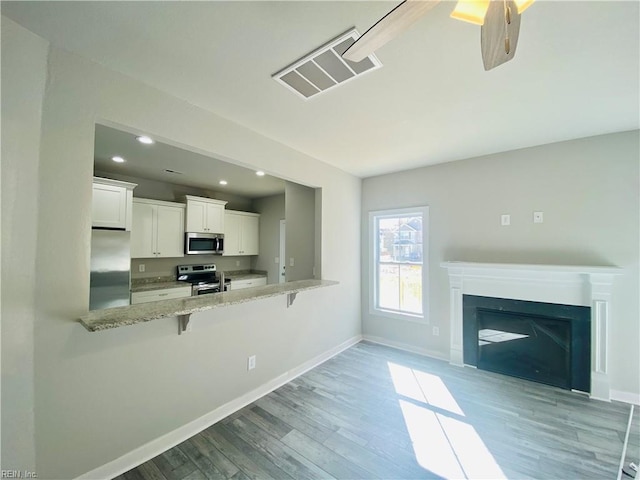 1400 Winslow Ave, Chesapeake, VA 23323 - kitchen featuring stainless steel appliances, a breakfast bar, recessed lighting, light wood-style flooring, and white cabinets