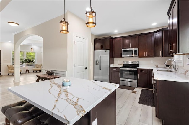 316 A Pocahontas Ave, Franklin, VA 23851 - kitchen with stainless steel appliances, arched walkways, dark brown cabinetry, light stone counters, and recessed lighting