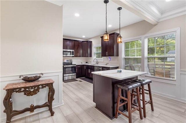 316 A Pocahontas Ave, Franklin, VA 23851 - kitchen with appliances with stainless steel finishes, ornamental molding, dark brown cabinetry, a breakfast bar area, and pendant lighting