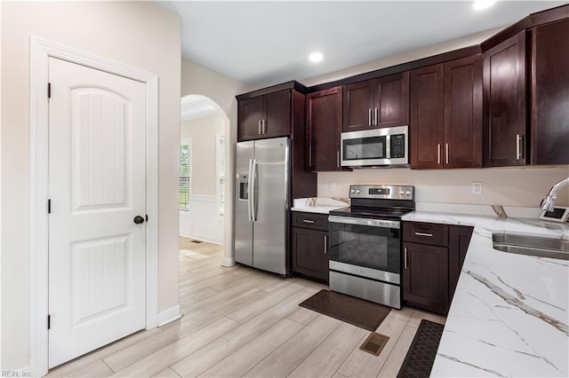 316 A Pocahontas Ave, Franklin, VA 23851 - kitchen featuring appliances with stainless steel finishes, arched walkways, light stone countertops, recessed lighting, and dark brown cabinets