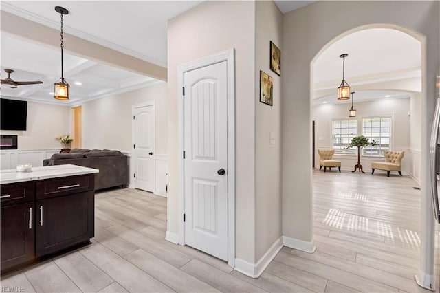 316 A Pocahontas Ave, Franklin, VA 23851 - kitchen featuring arched walkways, light wood-style floors, dark brown cabinets, beam ceiling, and hanging light fixtures