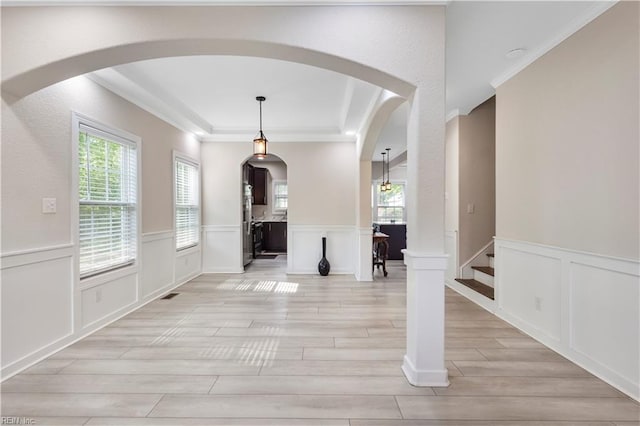 316 A Pocahontas Ave, Franklin, VA 23851 - unfurnished dining area featuring a decorative wall, light wood finished floors, arched walkways, crown molding, and wainscoting