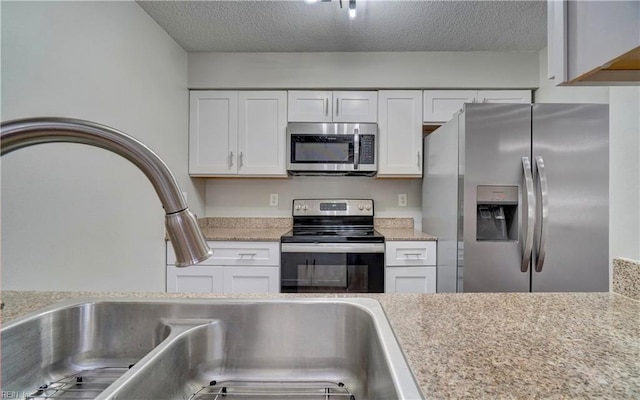 3856 Lasalle Dr Unit 107, Virginia Beach, VA 23453 - kitchen featuring stainless steel appliances, white cabinetry, light countertops, and a textured ceiling