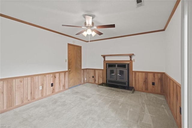 2024 Sarahs Cove Dr, Hayes, VA 23072 - unfurnished living room featuring a wood stove, a wainscoted wall, a ceiling fan, wood walls, and carpet floors