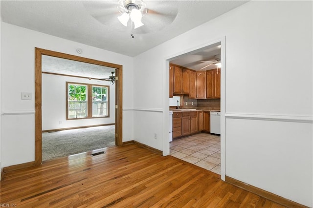 10 Watts Dr, Hampton, VA 23666 - kitchen with ceiling fan, dishwasher, light countertops, light wood finished floors, and brown cabinetry