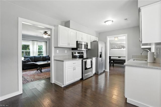 1245 Bells Mill Rd, Chesapeake, VA 23322 - kitchen with stainless steel appliances, dark wood-style floors, white cabinets, ceiling fan, and light stone counters