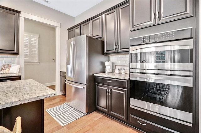 113 Saint Andrews, Smithfield, VA 23430 - kitchen with stainless steel appliances, light wood-style floors, tasteful backsplash, and light stone counters