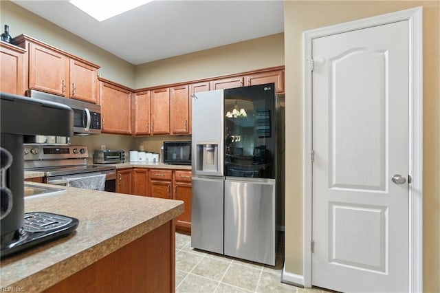 507 Marsh Hawk Trl, Carrollton, VA 23314 - kitchen with appliances with stainless steel finishes, brown cabinets, light tile patterned flooring, and light countertops