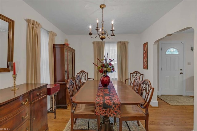 8579 Farys Mill Rd, Gloucester, VA 23061 - dining room featuring arched walkways, a chandelier, light wood-style floors, and healthy amount of natural light