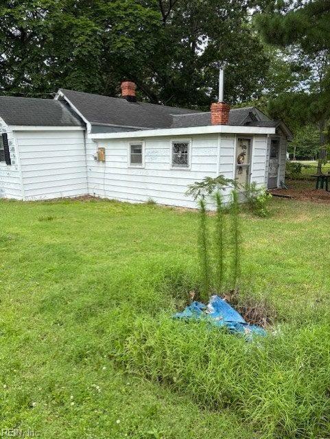 1993 Mark Pine Rd, Hayes, VA 23072 - rear view of house featuring a chimney, a yard, an outbuilding, and a shingled roof