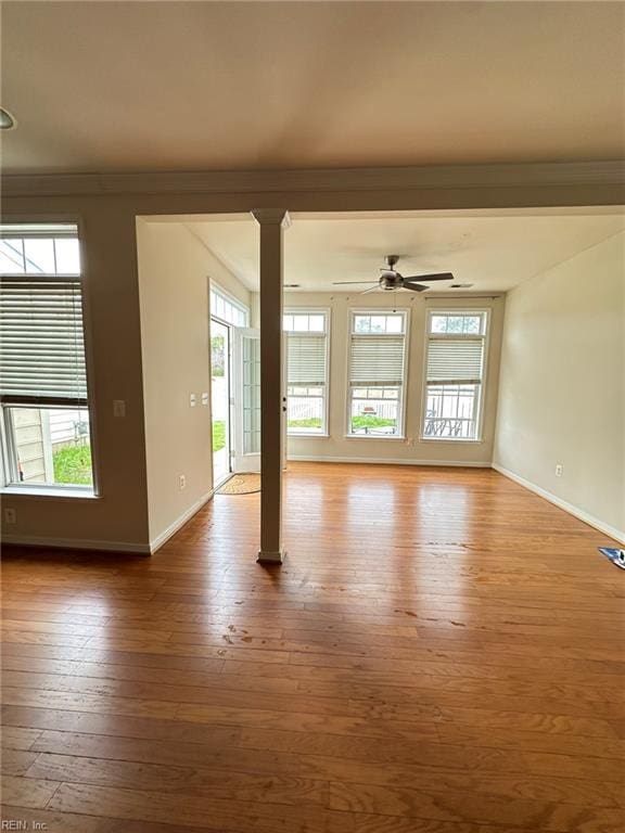 5837 Flowering Peach Ln, Providence Forge, VA 23140 - unfurnished living room with plenty of natural light, wood-type flooring, crown molding, ceiling fan, and ornate columns