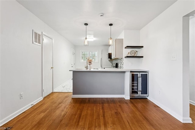 2734 Jamestown Ave, Hampton, VA 23661 - kitchen with wine cooler, open shelves, wood finished floors, a peninsula, and light countertops