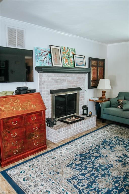 3728 Sidley Rd, Chesapeake, VA 23321 - living room with wood finished floors, crown molding, and a fireplace