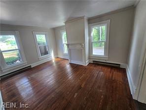 1697 Old Ferry Rd, Hudgins, VA 23076 - unfurnished living room with dark wood-type flooring, plenty of natural light, a baseboard heating unit, and crown molding