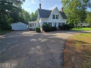 1697 Old Ferry Rd, Hudgins, VA 23076 - view of front of house with a garage, a storage unit, driveway, and a chimney