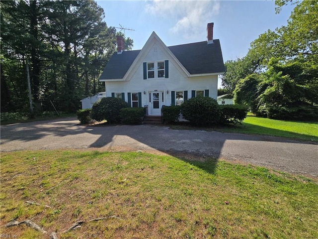1697 Old Ferry Rd, Hudgins, VA 23076 - view of front of house featuring a chimney, a front yard, and driveway