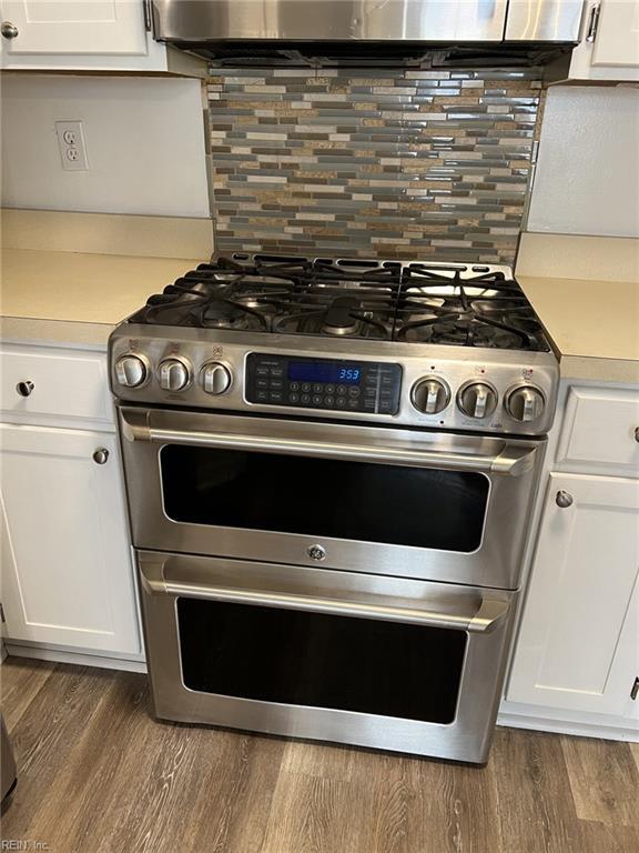 12803 Daybreak Cir, Newport News, VA 23602 - kitchen featuring range with two ovens, light countertops, white cabinets, and tasteful backsplash