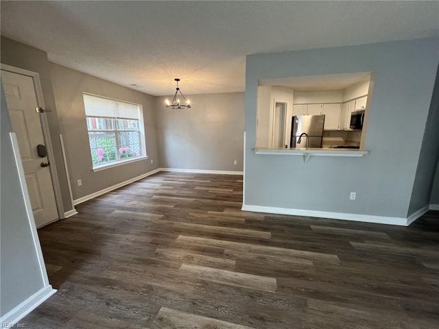 12803 Daybreak Cir, Newport News, VA 23602 - unfurnished living room with dark wood-style flooring, a chandelier, and a textured ceiling
