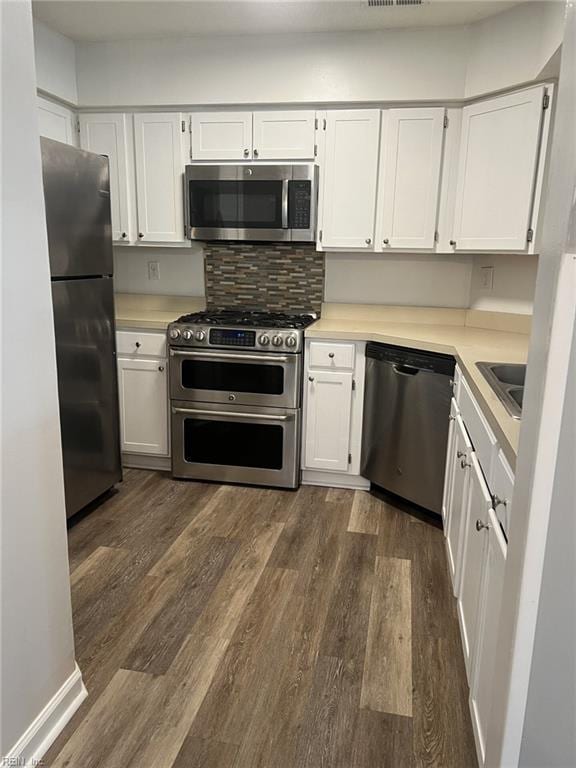 12803 Daybreak Cir, Newport News, VA 23602 - kitchen with stainless steel appliances, dark wood-style floors, light countertops, white cabinets, and decorative backsplash