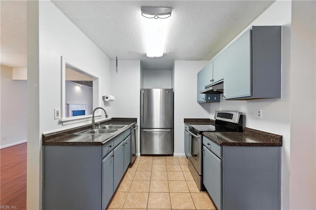 182 Old Bridge Rd, Newport News, VA 23608 - kitchen with appliances with stainless steel finishes, under cabinet range hood, dark countertops, a textured ceiling, and light tile patterned floors