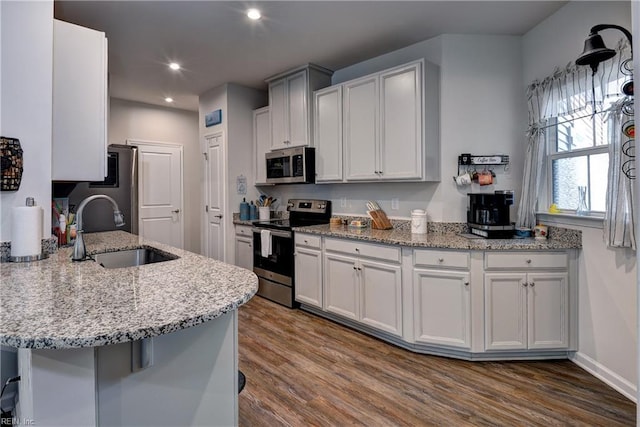 3419 Foxglove Dr, Toano, VA 23168 - kitchen featuring stainless steel appliances, dark wood-style floors, light stone countertops, recessed lighting, and a peninsula