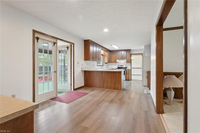 112 Farmington Blvd, Hampton, VA 23666 - kitchen with light wood-type flooring, a peninsula, light countertops, under cabinet range hood, and freestanding refrigerator