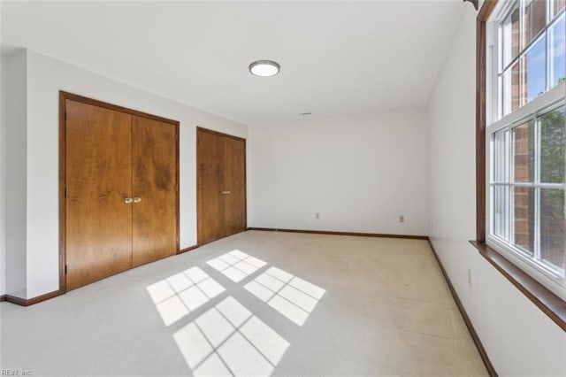 112 Farmington Blvd, Hampton, VA 23666 - unfurnished bedroom with multiple windows, two closets, and light carpet