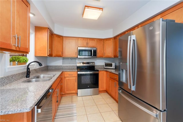 1964 Nettle St, Virginia Beach, VA 23453 - kitchen featuring stainless steel appliances, light tile patterned floors, brown cabinetry, and light stone counters