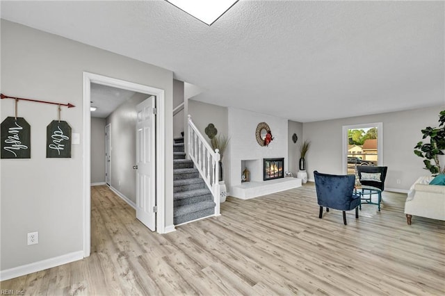 3905 Stonebridge Ct, Chesapeake, VA 23321 - living room with light wood finished floors, stairway, a fireplace, and a textured ceiling