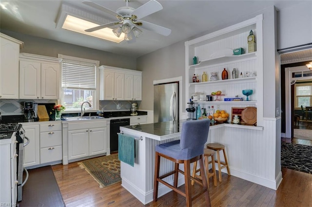 122 S Willard Ave, Hampton, VA 23663 - kitchen with appliances with stainless steel finishes, open shelves, wood finished floors, a kitchen breakfast bar, and wainscoting